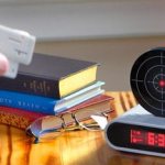 Alarm clock in the form of a target with a laser pistol